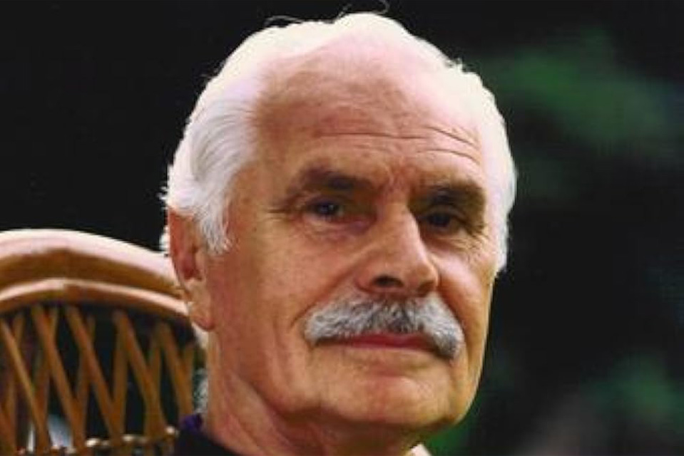 A man with white hair and a moustache, looking at the camera.